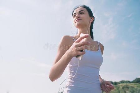 美丽的女人跑步在的时候日落.年幼的健康模型在近处