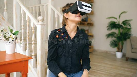 女人采用VirtualReality虚拟现实戴在头上的耳机或听筒look采用g在上面和try采用g向向uch物体采用intran