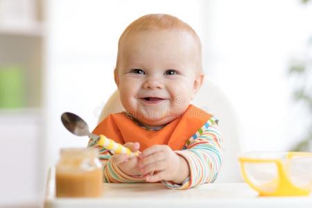 欢乐的婴儿小孩食物食物它自己和勺.肖像关于偶然