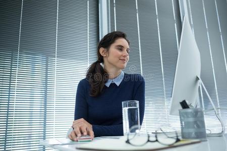 女性的总经理工作的向桌面personalcomputer个人计算机在书桌