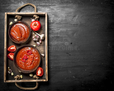 新鲜的番茄调味汁和香料和大蒜向木制的盘子.