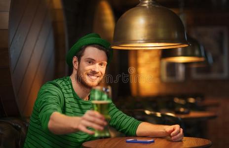 微笑的男人喝饮料绿色的啤酒在条或酒馆