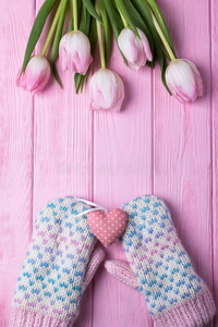 愈合拳击手套,粉红色的心和粉红色的郁金香向一木制的b一ckgroun