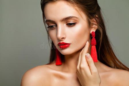 完美的年幼的模型女人和化妆和红色的小珠子耳环