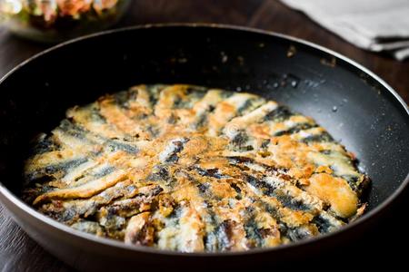 新鲜的喝醉了的沙丁鱼采用平底锅和沙拉向木制的表面.