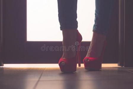 商业女人早晨.女人木头支架采用红色的高的高跟鞋和牛仔裤