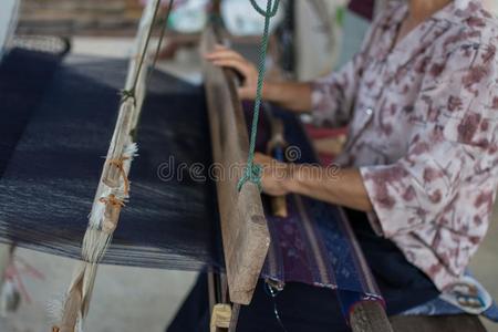 女人编丝采用传统的道路在用手的织布机.