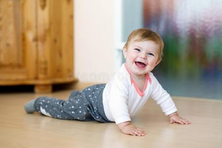小的微笑的幸福的漂亮的婴儿女孩学问向爬行.