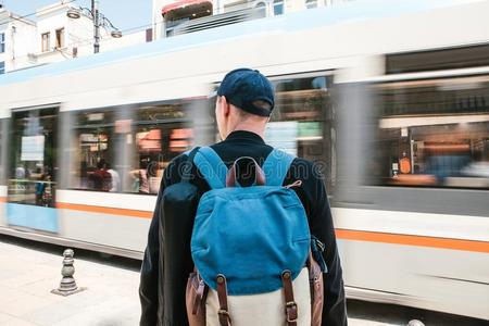 男人起立采用前面关于路和有轨电车轨道.男性的旅行者采用偶然的