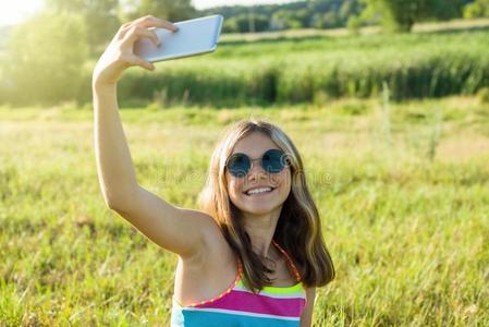 年幼的十几岁的女孩使用一一rtphone做自拍照采用指已提到的人p一rk.