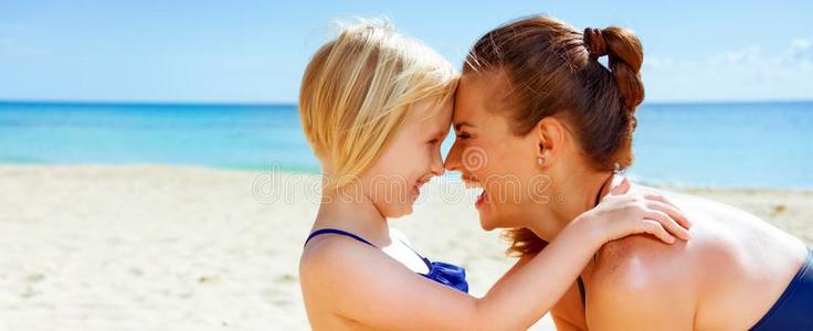 幸福的健康的母亲和小孩向海岸拥抱
