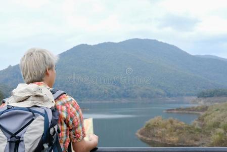 旅行支票男人和地图,背包旅行在山&湖采用总数