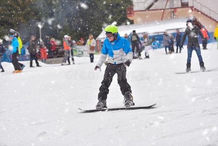 年幼的男人向滑雪板向山下和人采用指已提到的人背景