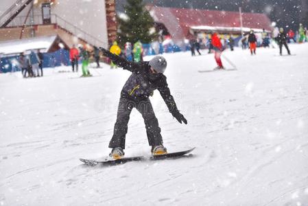 年幼的男人向滑雪板向山下和人采用指已提到的人背景