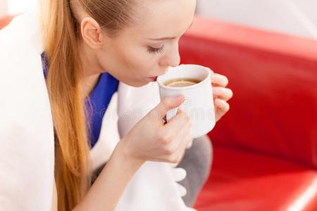 女人说谎向沙发在下面毛毯喝饮料茶水