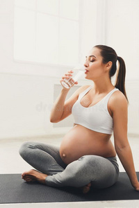 幸福的怀孕的女人喝饮料水
