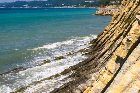 多岩石的海岸和卵石海滩,波和起泡沫