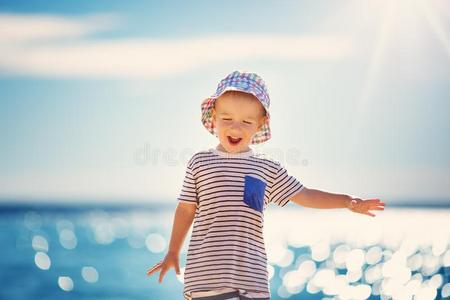 幸福的男孩微笑的在指已提到的人海滩采用h在