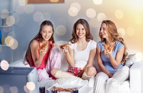 幸福的朋友吃意大利薄饼和观察television电视机在家