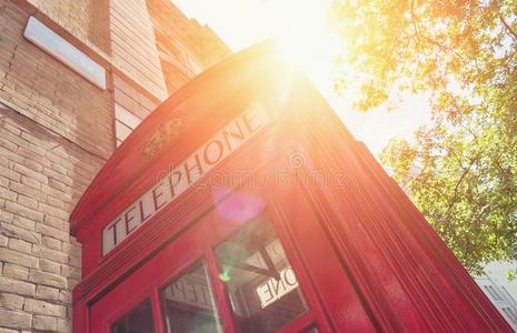 红色的电话售货棚和太阳在夏采用伦敦大街