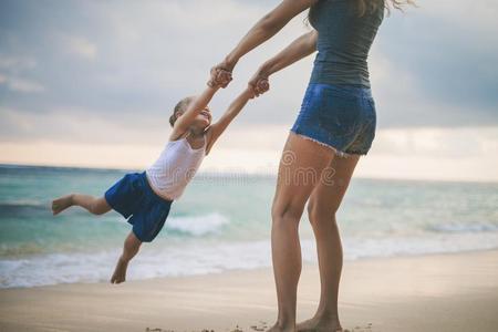 妈妈和婴儿演奏在近处海滩.同行的和家庭,小孩