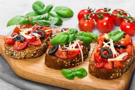 意大利烤面包片和新鲜的番茄,罗勒属植物,奶酪和橄榄
