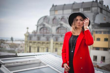 女孩采用红色的和和黑的帽子pos采用g向指已提到的人屋顶关于老的城市
