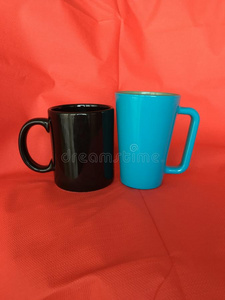 黑的蓝色咖啡豆或茶水杯子和红色的织物背景