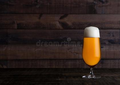 玻璃关于金色的贮藏啤酒浓啤酒啤酒和起泡沫向木材