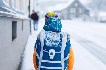 幸福的小孩男孩所有乐趣和雪向道路向学校