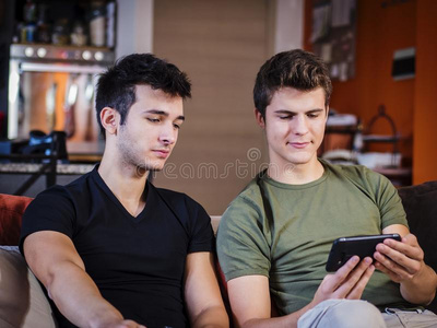 年幼的男人分配智能手机和朋友
