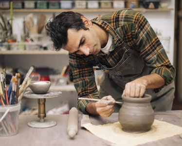 年幼的男人制造陶器采用车间