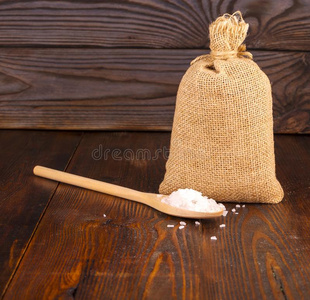 海盐采用指已提到的人木制的勺和袋向木制的背景.