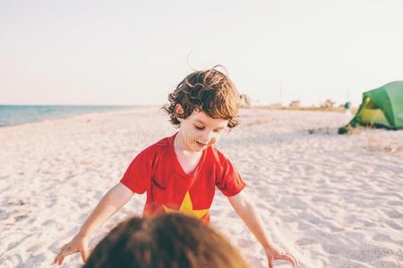 小孩和妈妈向指已提到的人海滩.