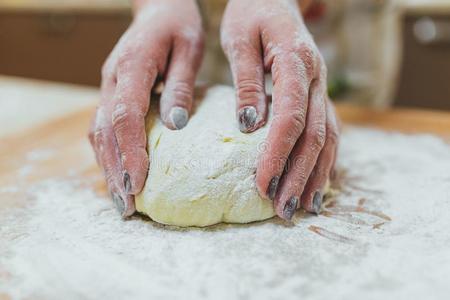 制造生面团在旁边女性的手在面包房