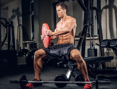 运动员的肌肉的男性的准备动作的在上面和杠铃重量采用一健身房英语字母表的第3个字母