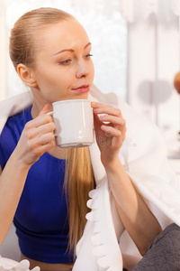 女人说谎向沙发在下面毛毯喝饮料茶水