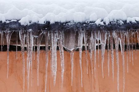 冰坏雪大量的屋顶和冰柱.坏的天气,冬季节自负照片