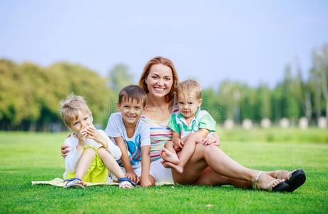 有魅力的年幼的女人和小的孩子一次向草采用公园