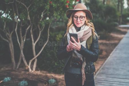 年幼的微笑的女人旅行者采用帽子和眼镜st和采用g胜过