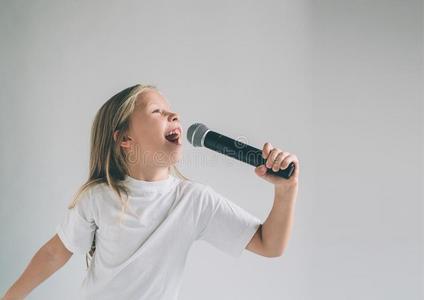 影像关于一小孩唱歌向指已提到的人扩音器,是(be的三单形式照片