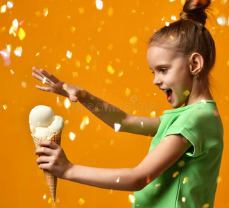 漂亮的婴儿女孩小孩拿住白色的香蕉冰乳霜采用蛋奶烘饼圆锥体
