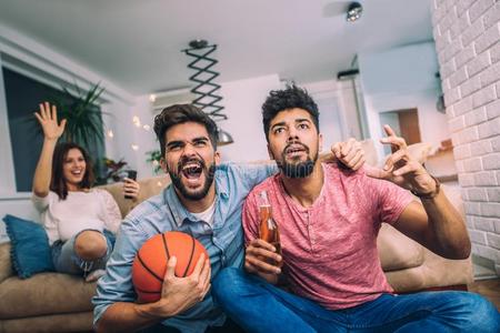 幸福的朋友或篮球粉丝观察篮球游戏向television电视机