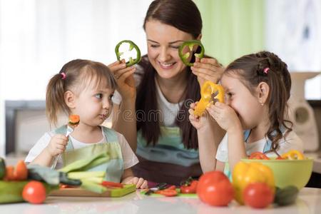 幸福的家庭妈妈和小孩所有乐趣和食物蔬菜在衣物和装备