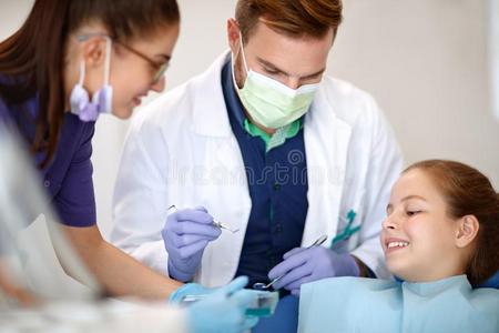 女性的助手和男性的牙科医生纠正小孩`英文字母表的第19个字母牙