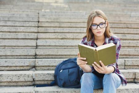 年幼的女人阅读书向综合性大学楼梯