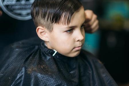 指已提到的人男孩获得理发在旁边剪采用理发店.理发师使用science科学
