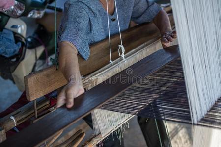 女人编丝采用传统的道路在用手的织布机.
