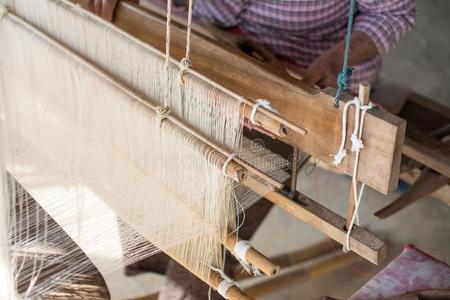 女人编丝采用传统的道路在用手的织布机.