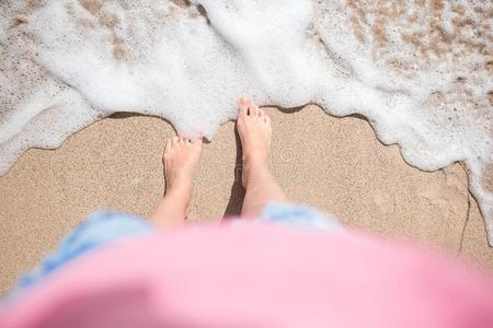 关在上面关于女性的脚向白色的沙的海滩